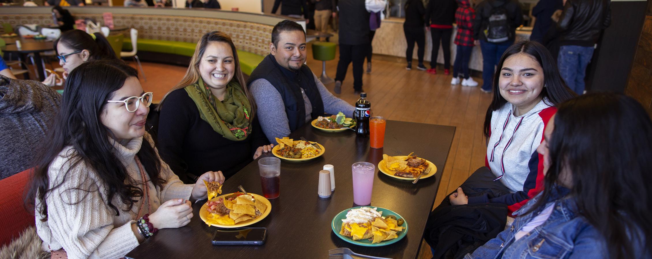 Una familia comiendo en un puesto en un comedor del campus.