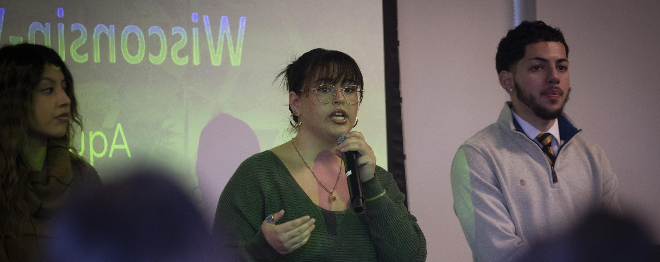 A student speaks in front of a crowd.