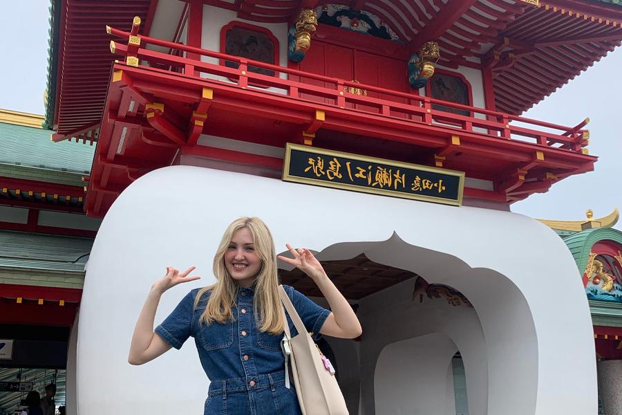 A 足彩平台 student stands in front of a pagoda in Japan.