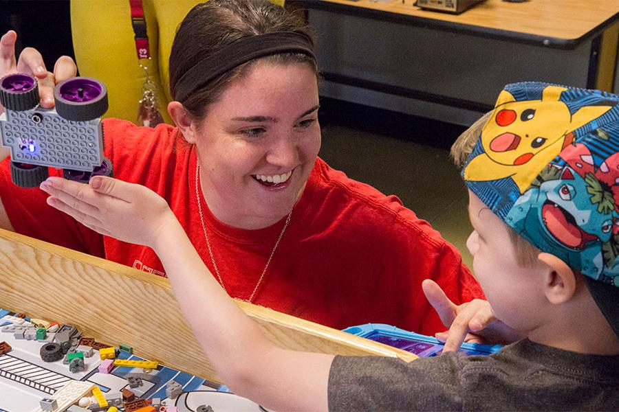 Early childhood teacher helping student in class