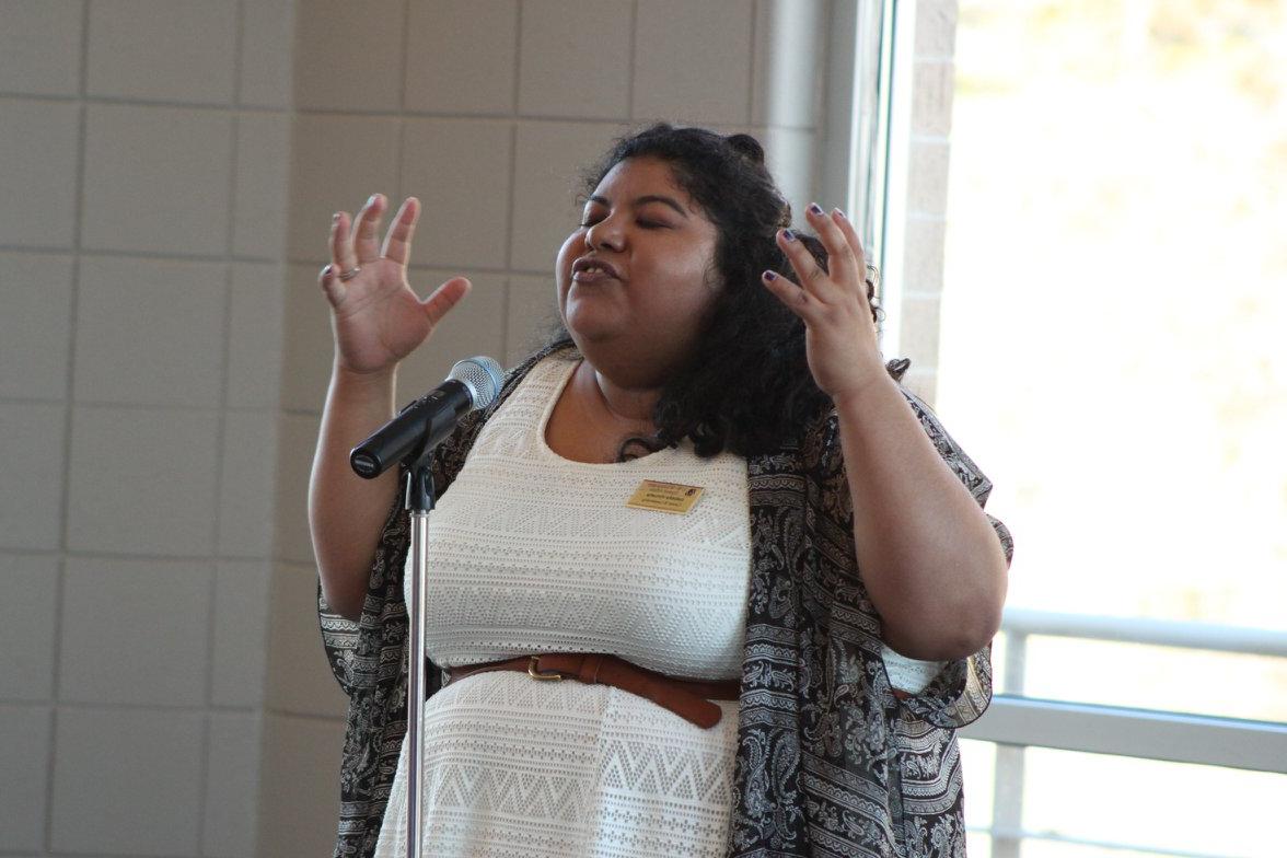 Pride Graduate Assistant performing a monologue at the Rainbow Celebration of Excellence. 