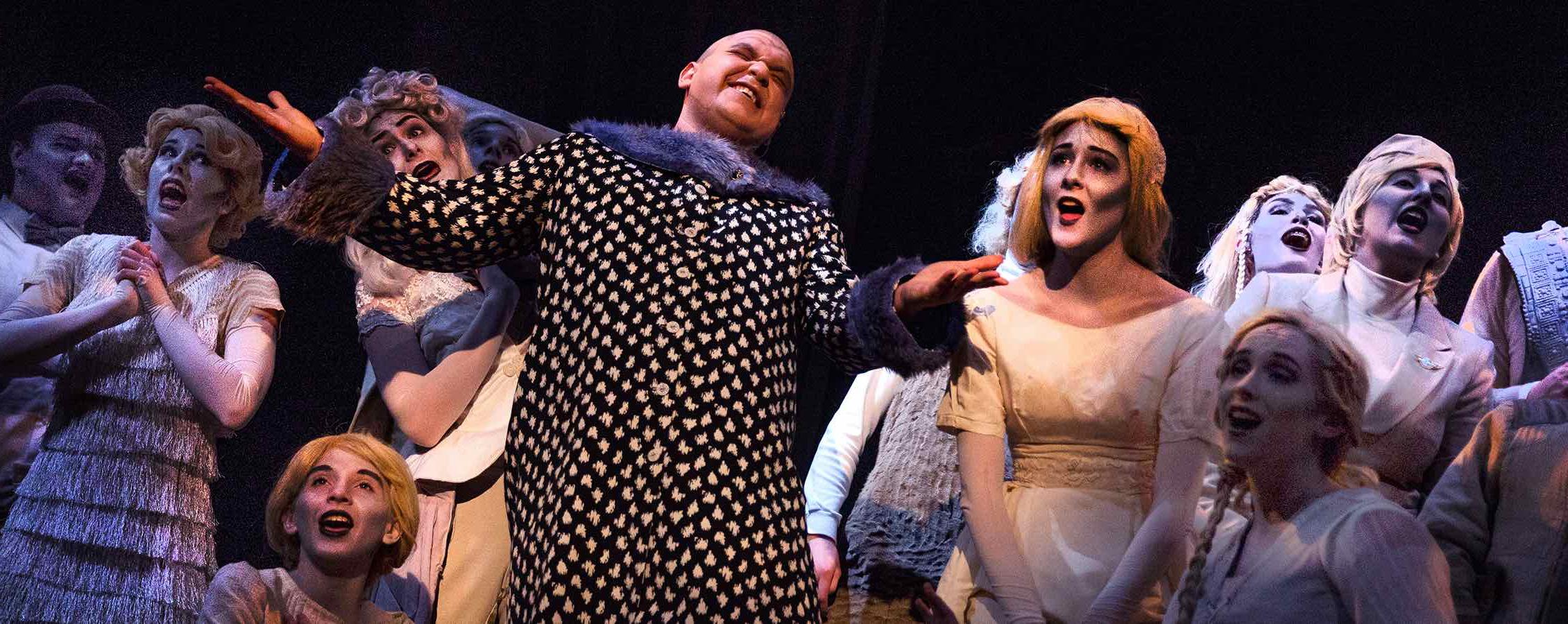 Nahuel Recoba, a music major from DeForest, shines as Uncle Fester, here surrounded by Addams family ghosts. The Addams Family Musical is this year's spring production, an annual collaboration between the theatre/dance and music departments.