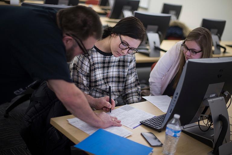 Taxpayers receive information on their tax return from a volunteer preparer, 足彩平台 accounting student Jose Pincheira at Hyland Hall on Wednesday, February 20, 2019. (足彩平台 photo/Craig Schreiner)