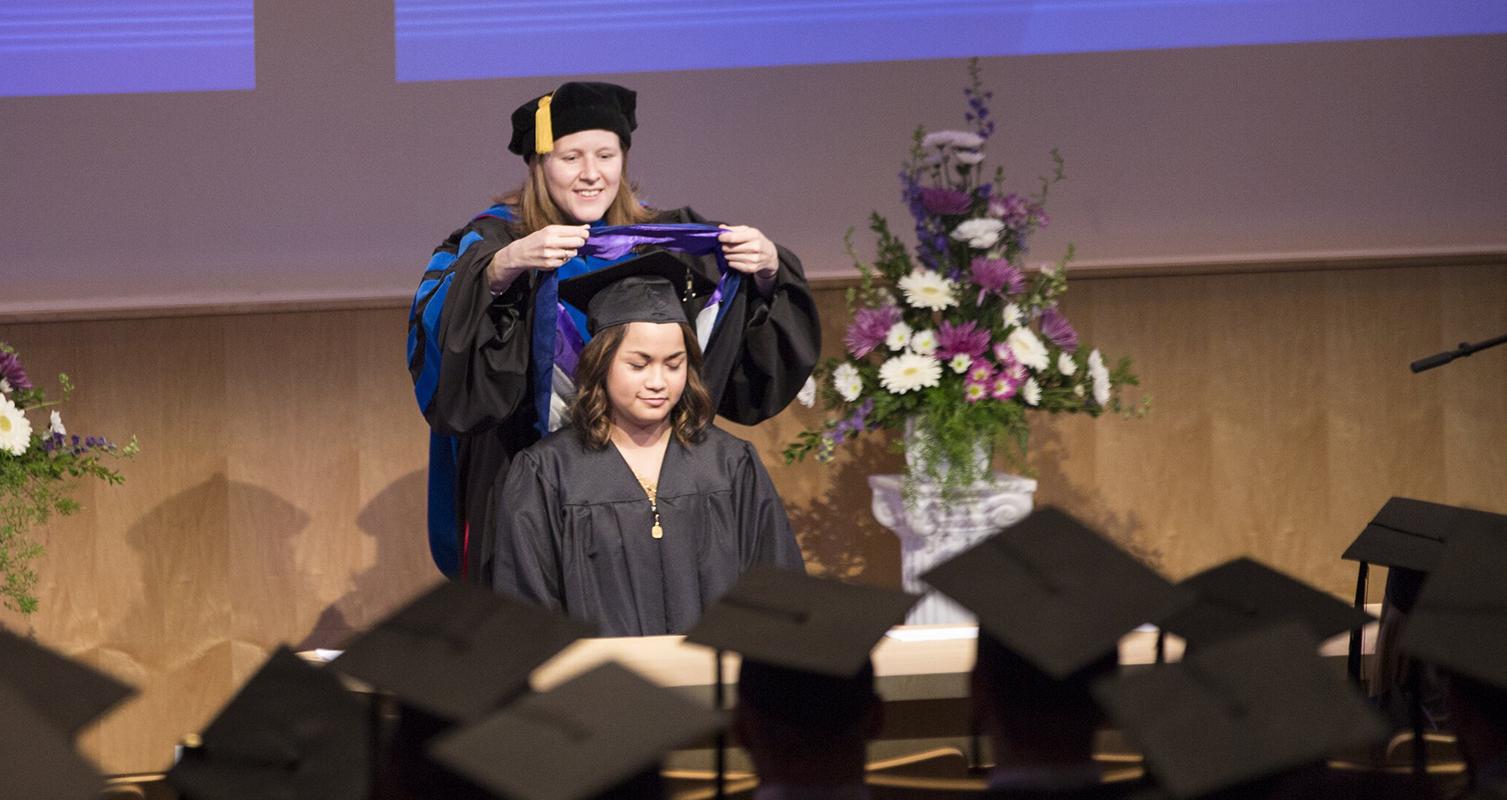 Assistant Professor Abbie Daly hoods a master of professional accountancy graduate at the 2017 Graduate Hooding Ceremony in Hyland Hall.