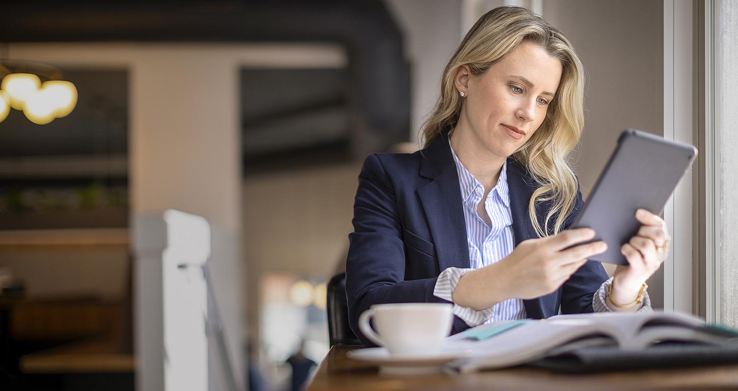 Woman studying with a tablet by cafe window