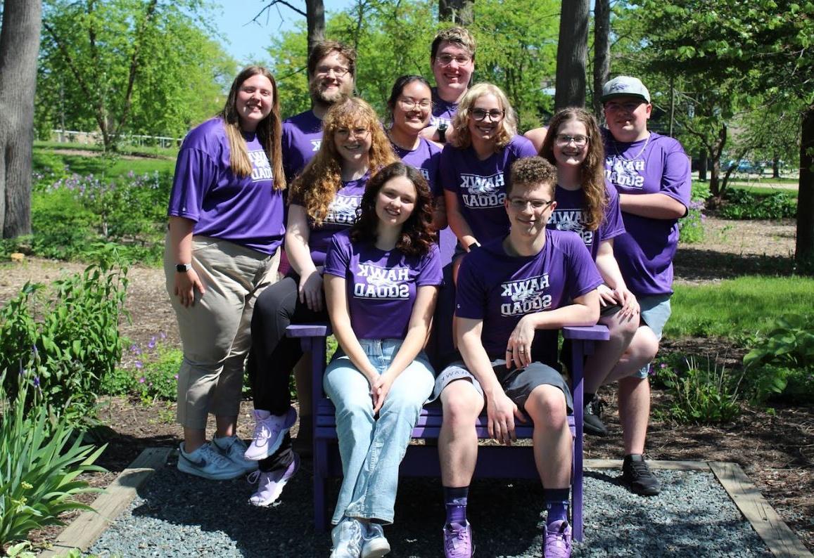 10 students in Hawk Squad purple shirts looking at camera