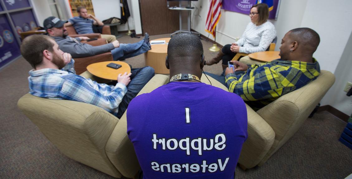 Man sitting while wearing a shirt that reads I Support Veterans