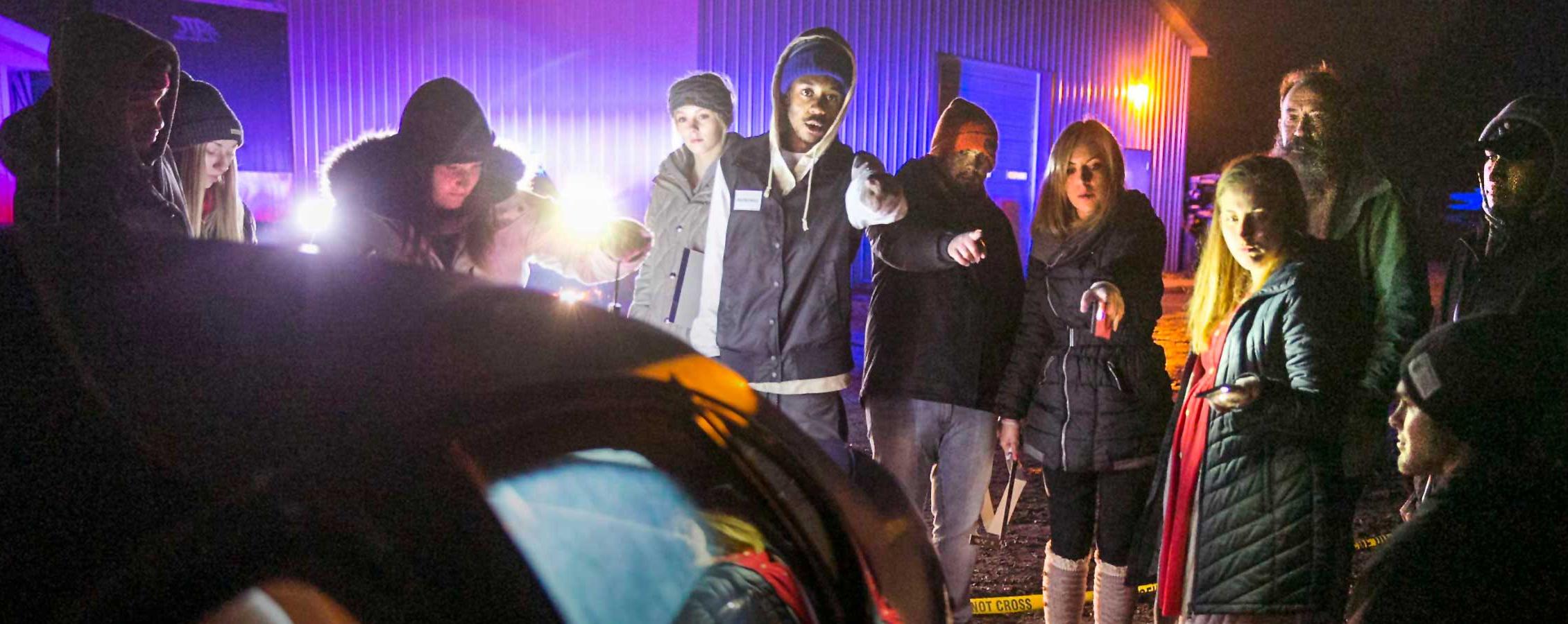 Students stand around a simulated crime scene.