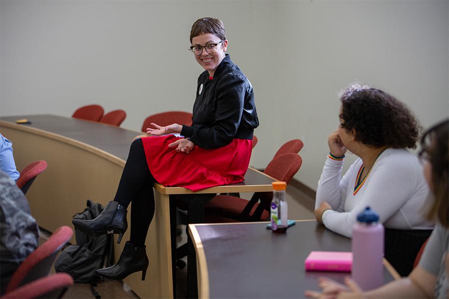 Stephanie Selvick sitting on a table talking with students.