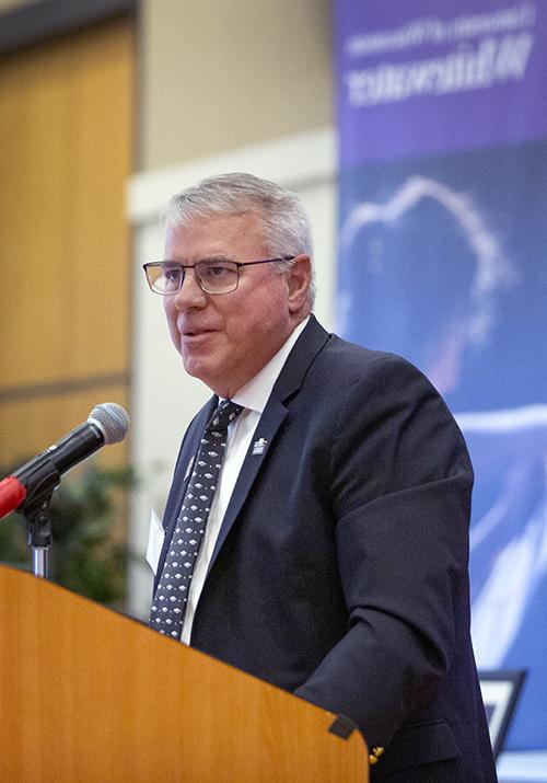 Timothy Hyland speaks at a podium.