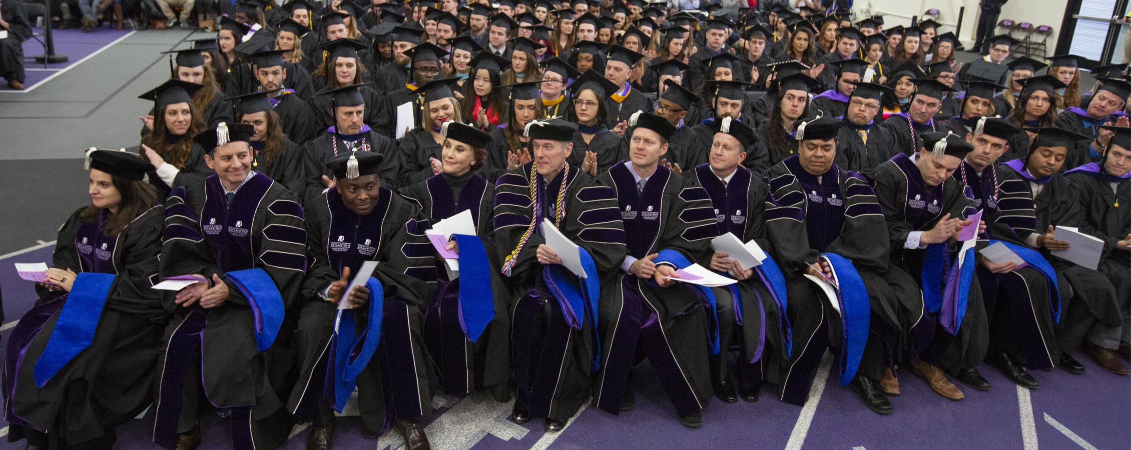 Members of the first cohort of Doctor of Business Administration graduates at 足彩平台 sit in the front row at commencement.