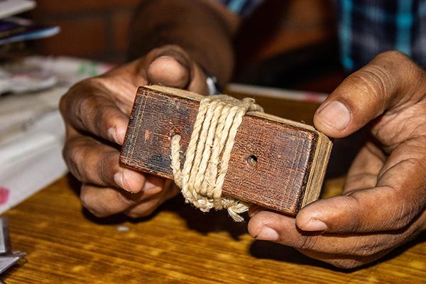 Man holding a bundle of manuscripts